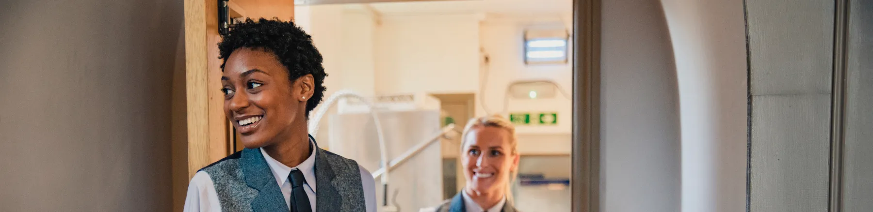 Smiling catering staff at Woburn House bringing plates of food at an event