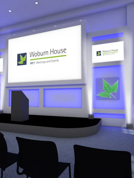 Modern conference room with a podium, large screen displaying "Woburn House," blue-lit walls, row of empty black chairs, and a bright, professional ambiance.