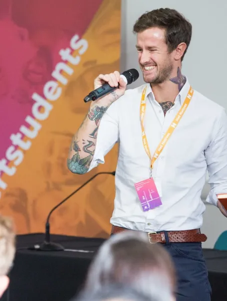 Man giving a talk while holding a mic